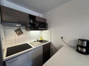 a small kitchen with a sink and a microwave at Résidence Bois Des Coqs - Studio confortable · Proche des pistes · Coin montagne & parking extérieur MAE-0294 in Champcella +7 photos