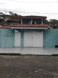 a house with three garage doors in front of it at Casa Ilhabela in Ilhabela