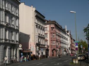 eine belebte Stadtstraße mit Gebäuden in einer Stadtstraße in der Unterkunft Hotel garni Djaran in Offenbach