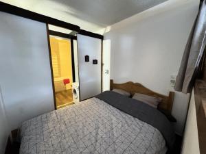a bedroom with a large bed with a window at Résidence Les Melezes - Studio chaleureux & rénové · Accès pistes par navette · Vue sur les pistes MAE-0784 in Champcella
