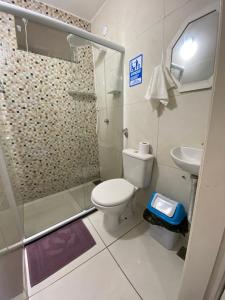 a bathroom with a shower and a toilet and a sink at Âncora Suítes Arraial do Cabo in Arraial do Cabo