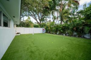 Un patio verde con pelotas de golf en el césped. en New Luxury Villa Delilah Biscayne Park, en Biscayne Park