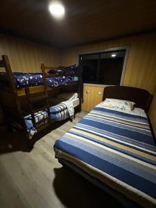 a bedroom with two bunk beds and a window at Cabaña del Llicanko in Achao