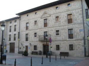 un gran edificio de piedra con un banco delante en Arganzón Plaza, en La Puebla de Arganzón