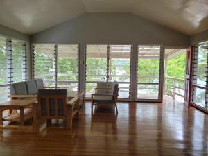 a dining room with a table and chairs and windows at Seghe Accommodation in Seghe