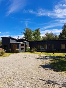 a house with a gravel driveway in front of it at Casa campo in Puerto Varas