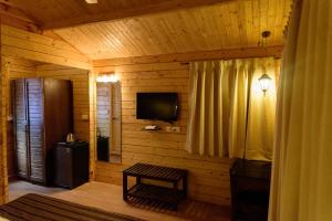 a log cabin with a television and a window at Tranquility Cottage Resorts in Baga