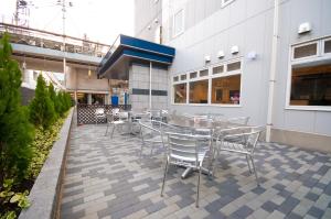 a patio with a table and chairs in front of a building at Super Hotel Kokuraeki Minamiguchi in Kitakyushu