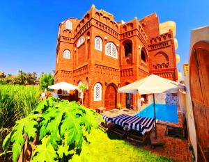 卢克索Luxor Tower的一座带游泳池和遮阳伞的大型砖砌建筑