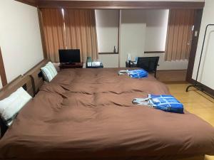 un grand lit dans une chambre d'hôtel avec deux serviettes dessus dans l'établissement フォレスタ阿蘇車帰, à Aso