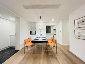 Bund Branch New west door 2 bedrooms big house في شانغهاي: غرفة طعام مع طاولة سوداء وكراسي برتقالية