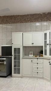 a kitchen with white cabinets and a stove at شقة رائعة لسياحة في جازان in Jazan