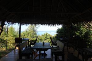 a restaurant with tables and chairs and a view of the ocean at Chomjan Resort in Ko Phayam