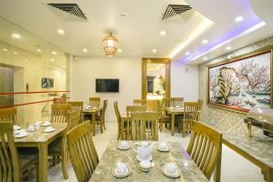a dining room with wooden tables and chairs at The Airport Hotel in Ho Chi Minh City