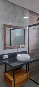 a bathroom with a sink and a mirror on a counter at Casa Ilhabela in Ilhabela