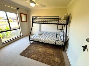 a bedroom with two bunk beds and a window at Bignell Family Home-Stay in Broadwater