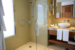 a bathroom with a glass shower and a sink at Yas Island Rotana Abu Dhabi in Abu Dhabi