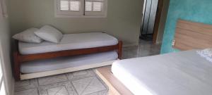 a room with two beds and a window at Casa Ilhabela in Ilhabela