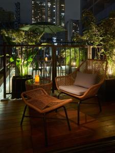 a balcony with two chairs and an umbrella at Hotel Tokyo Trip Ueno Nishi Nippori in Tokyo