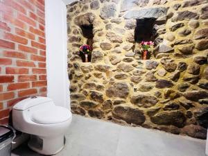 ein Badezimmer mit einer Steinmauer und einem WC in der Unterkunft Casa de piedra en Ollantaytambo in Ollantaytambo + 33 Fotos