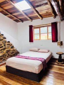 ein Schlafzimmer mit einem großen Bett in einem Zimmer in der Unterkunft Casa de piedra en Ollantaytambo in Ollantaytambo