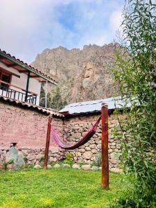 eine Steinmauer mit einer Hängematte vor einem Haus in der Unterkunft Casa de piedra en Ollantaytambo in Ollantaytambo