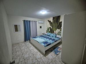 ein kleines Schlafzimmer mit einem Bett in einem Zimmer in der Unterkunft Tahir & Tamir Apartment in Willemstad