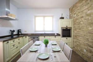 una cucina con un tavolo di legno con sedie e un tavolo sidx sidx sidx di Casa Carmen a Nerja