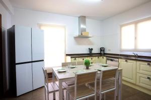 una cucina con tavolo con sedie e frigorifero di Casa Carmen a Nerja