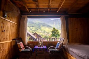 a room with two chairs and a table and a window at Sapa Ta Van Desi House - Mountain View & Hiking Tours in Sapa +120 photos