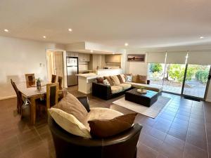 ein Wohnzimmer mit Sofa und Tisch in der Unterkunft SeventyThree at Cape View Resort in Broadwater