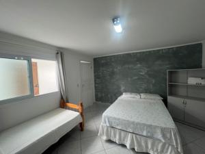 a bedroom with a bed and a chalkboard wall at Boas Vindas in Guarujá