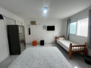 a room with a bed and a refrigerator in it at Boas Vindas in Guarujá