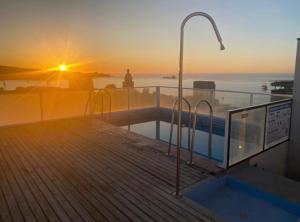 Blick auf den Sonnenuntergang über dem Meer auf ein Gebäude in der Unterkunft Departamento cerro barón in Valparaíso