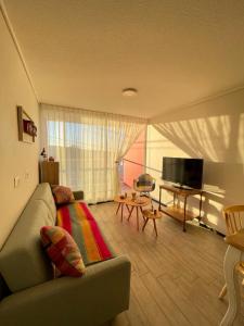 ein Wohnzimmer mit Sofa und Flachbildfernseher in der Unterkunft Departamento cerro barón in Valparaíso