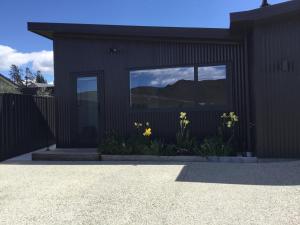 亚历山德拉Modern and stylish in Meyer的前面有黄色花的黑色建筑