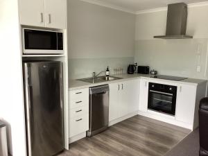 亚历山德拉Modern and stylish in Meyer的配有白色橱柜和不锈钢冰箱的厨房