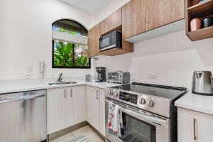 a kitchen with a stove and a sink at Pool Oasis, Concierge & 5min drive to the Beach in Playa Flamingo
