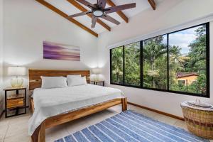 a bedroom with a bed and large windows at Pool Oasis, Concierge & 5min drive to the Beach in Playa Flamingo