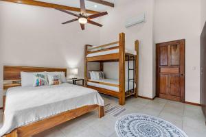 a bedroom with a bunk bed and a ceiling fan at Pool Oasis, Concierge & 5min drive to the Beach in Playa Flamingo +10 photos