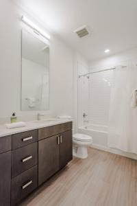 a bathroom with a sink and a toilet and a tub at Cozysuites l Luxe 2BR in Downtown Cincinnati #2 in Cincinnati