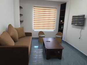 a living room with a couch and a table and a window at Tersha Homestay 2BHK in Shillong