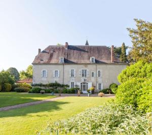 a large white house with a large yard at Domaine Labattut in Saint-Astier