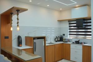 a kitchen with wooden cabinets and a refrigerator at ZERA cottage in Pīrmed