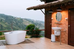 a bathroom with a tub and a toilet on a balcony at Oasis Yurt Villa @ Doi Lan - โอเอซิส เยิร์ต วิลล่า @ ดอยล้าน in Ban Huai Khai