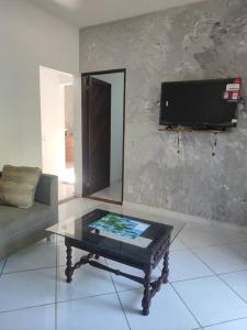 a living room with a coffee table and a tv at Sol&Mar Paraty Mirim in Paraty