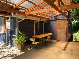 a wooden pergola on a patio with a table and chairs at Cabaña Quillón El Campito in Quillón
