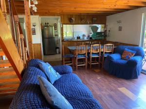a living room with a blue couch and a kitchen at Cabaña Quillón El Campito in Quillón