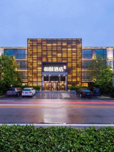 a large building with cars parked in front of it at Yitel Beijing Zhongguancun Software Park in Beijing