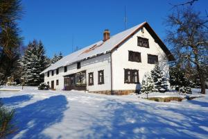 una casa blanca con nieve en el suelo en Chalupa pod Klepáčem, en Králíky